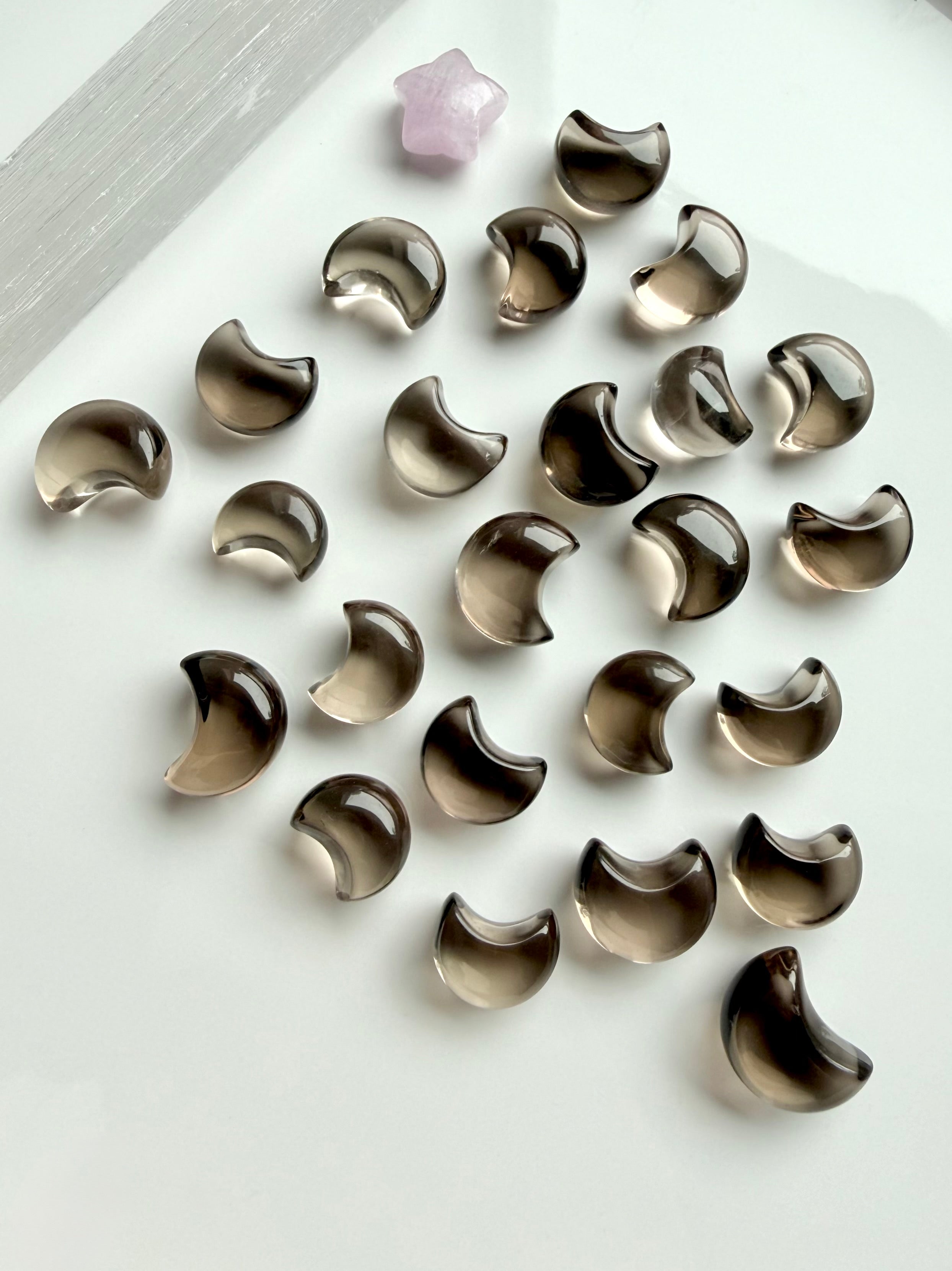 Mini Smoky Quartz moon carvings with translucent smoky brown and champagne tones in a range of tiny crescent moon sizes