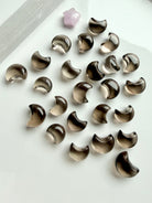 Mini Smoky Quartz moon carvings with translucent smoky brown and champagne tones in a range of tiny crescent moon sizes