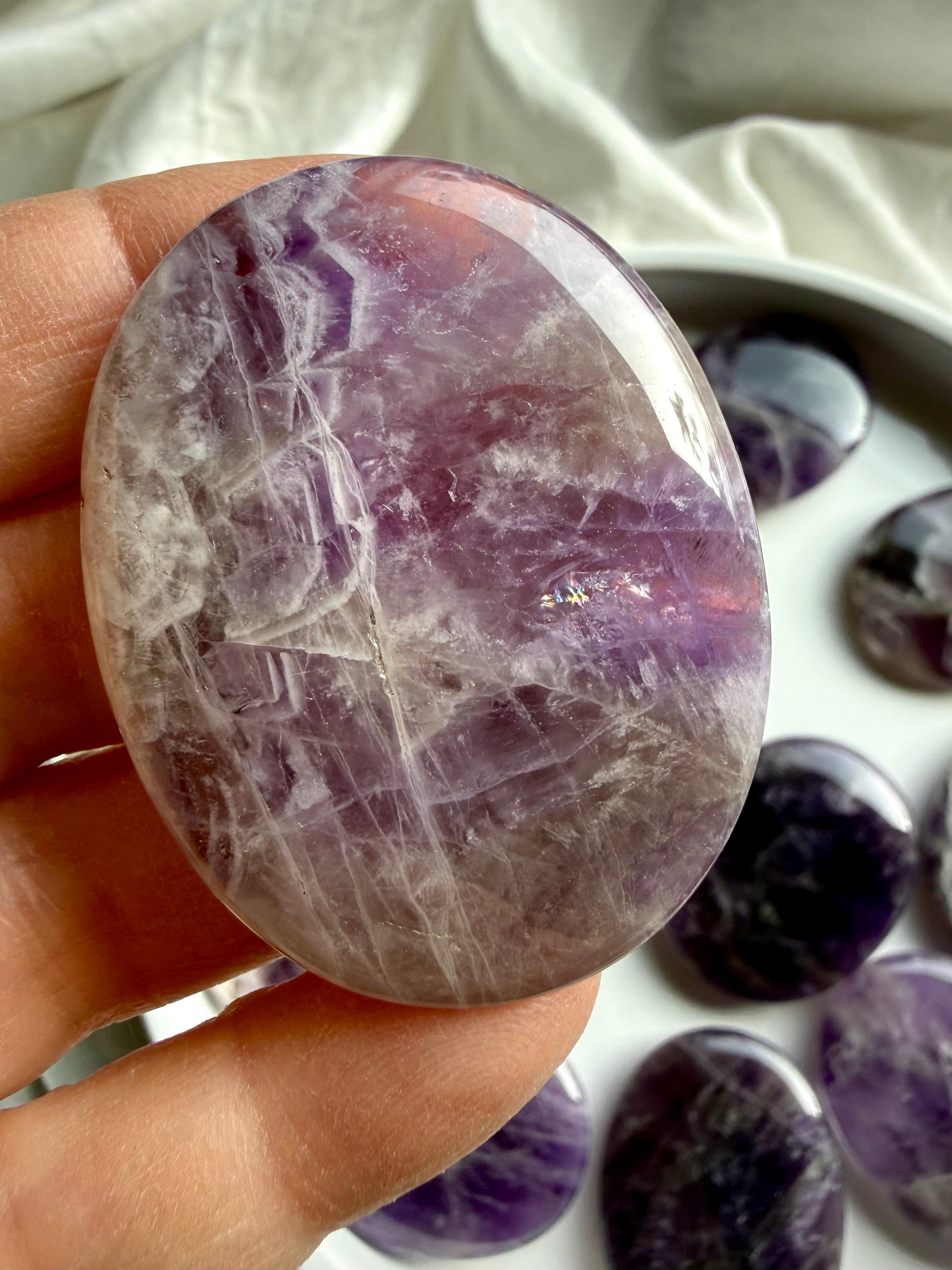 Dream amethyst flat palm stone held in hand, soothing amethyst meditation stone for sleep and relaxation