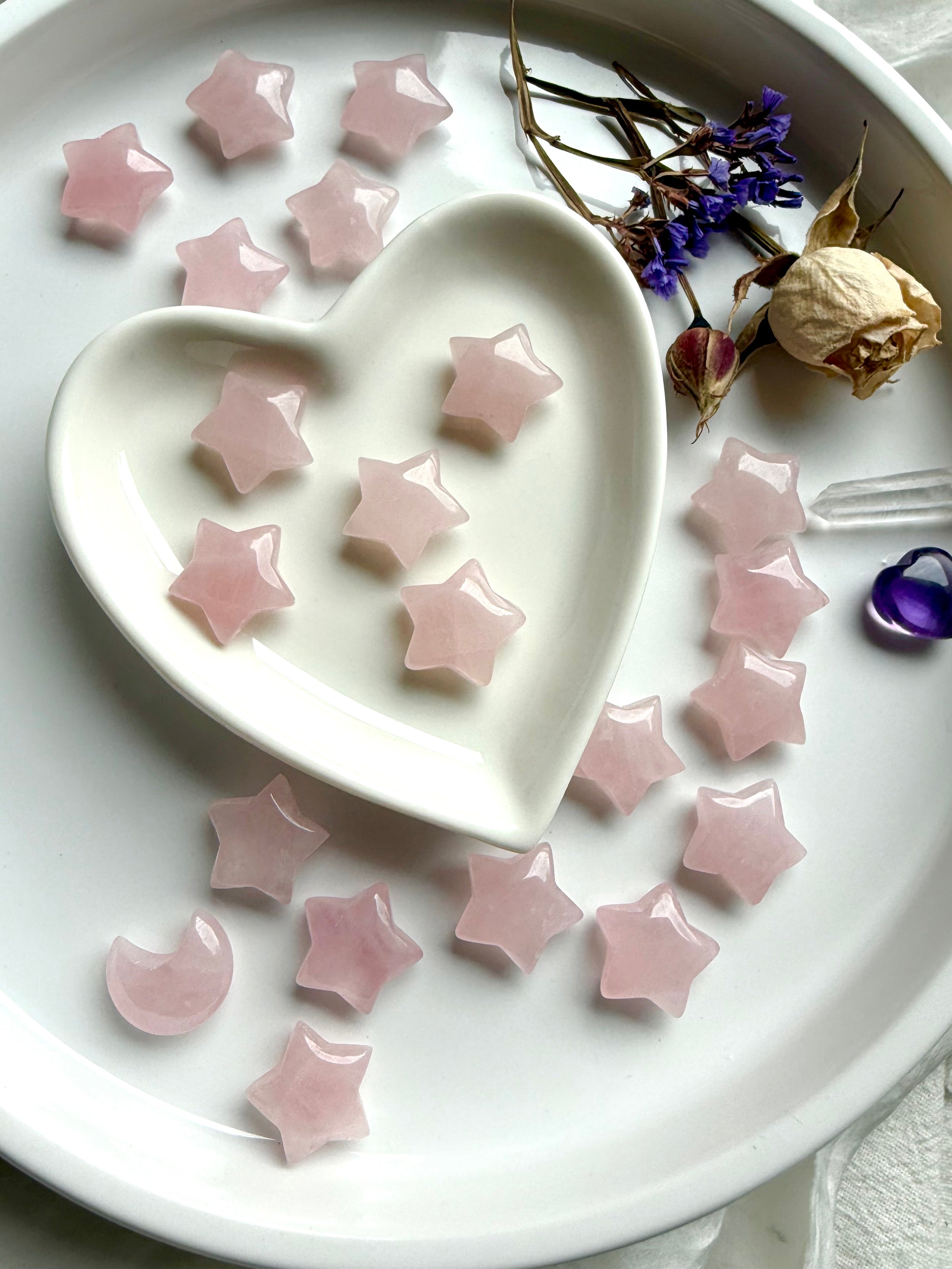 Small Rose Quartz star carvings on white. Celestial Heart Chakra stones for love, harmony, and intention-setting rituals.