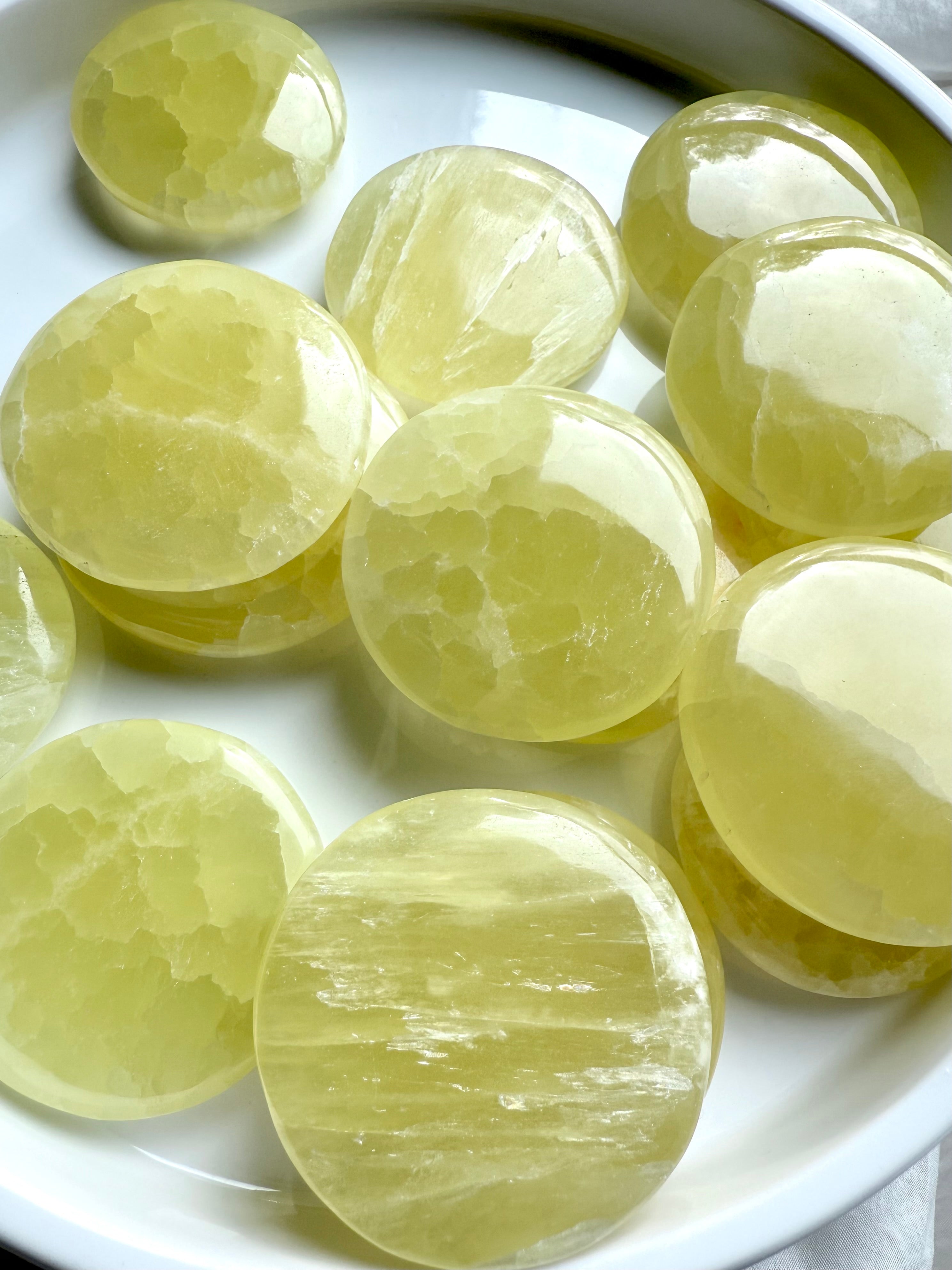 Lemon calcite discs in bright light highlighting natural banding and variation