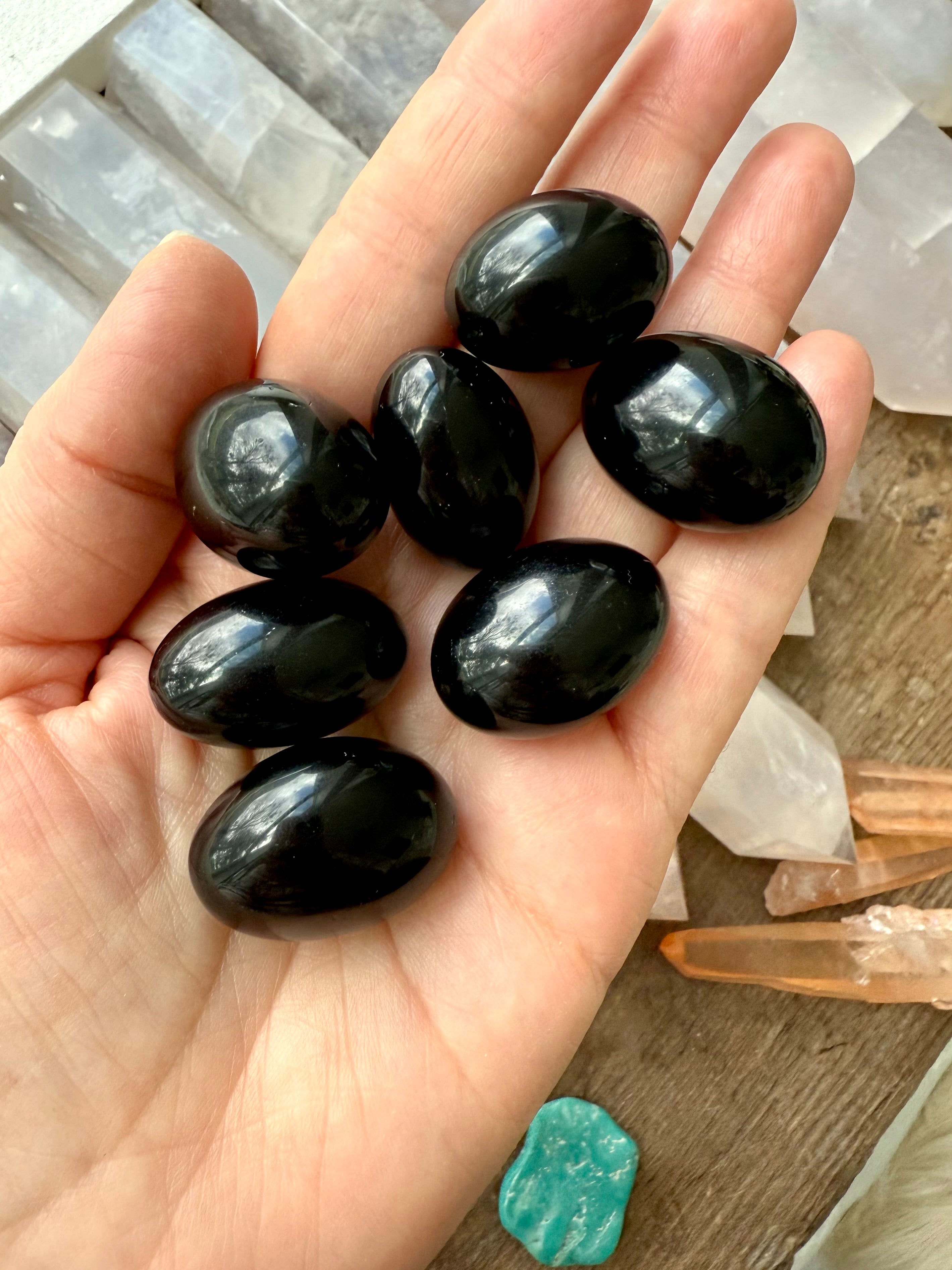 Black Obsidian Tumbled Stones shown on my hand for scale, photographed in natural light