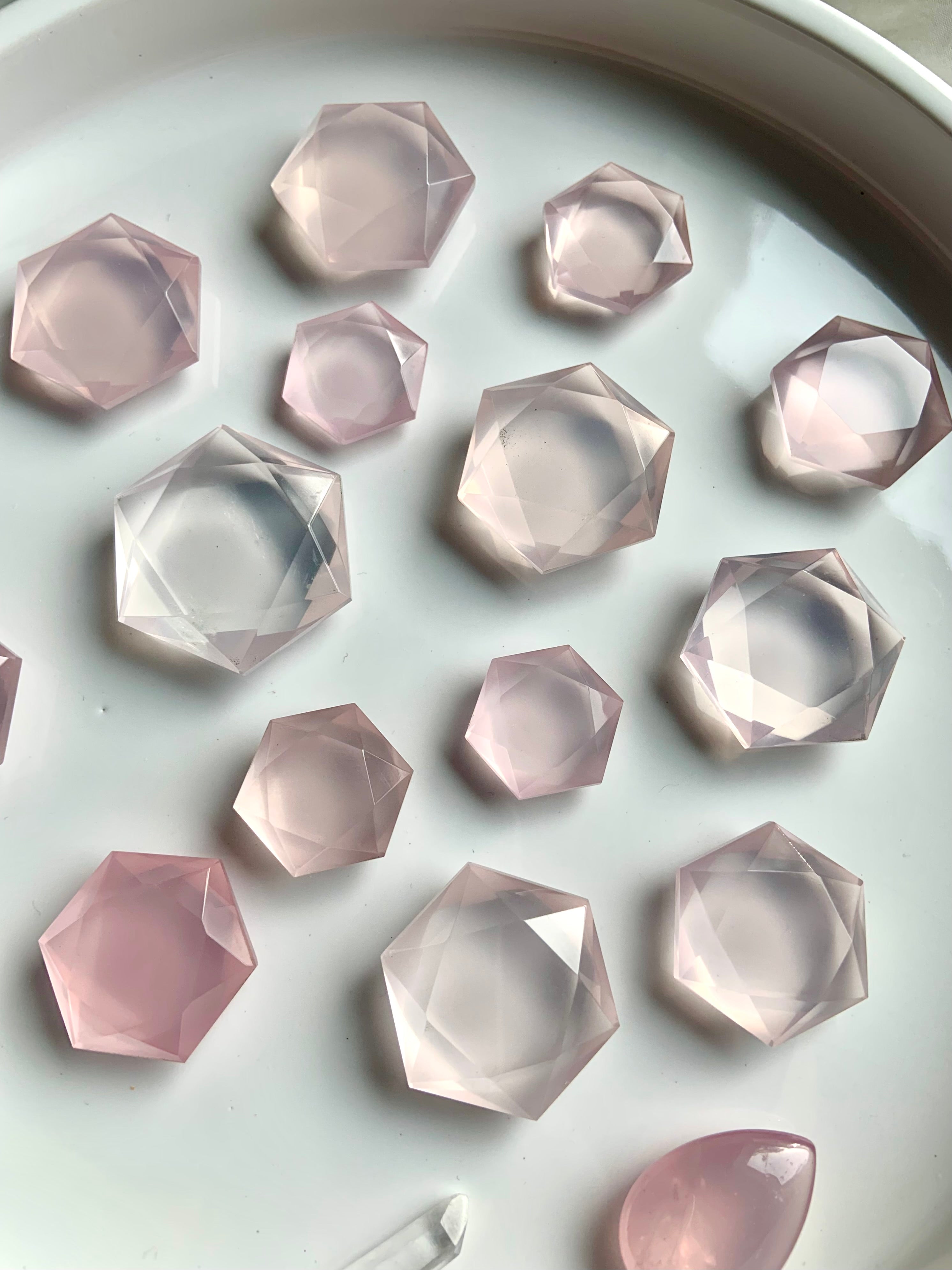 Wide view of faceted Rose Quartz hexagon crystals in mixed sizes, luminous pink sacred geometry stones for collectors and energy healing