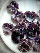 dream amethyst heart worry stones close up showing natural chevron patterns and polish