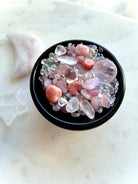 Black Obsidian bowl filled with Rose Quartz crystal confetti for altar decor