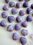 Closeup of Small polished Lilac Lepidolite heart stones with natural lavender marbling