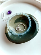 polychrome jasper bowl with natural teal wave pattern holding jewelry rings and crystals