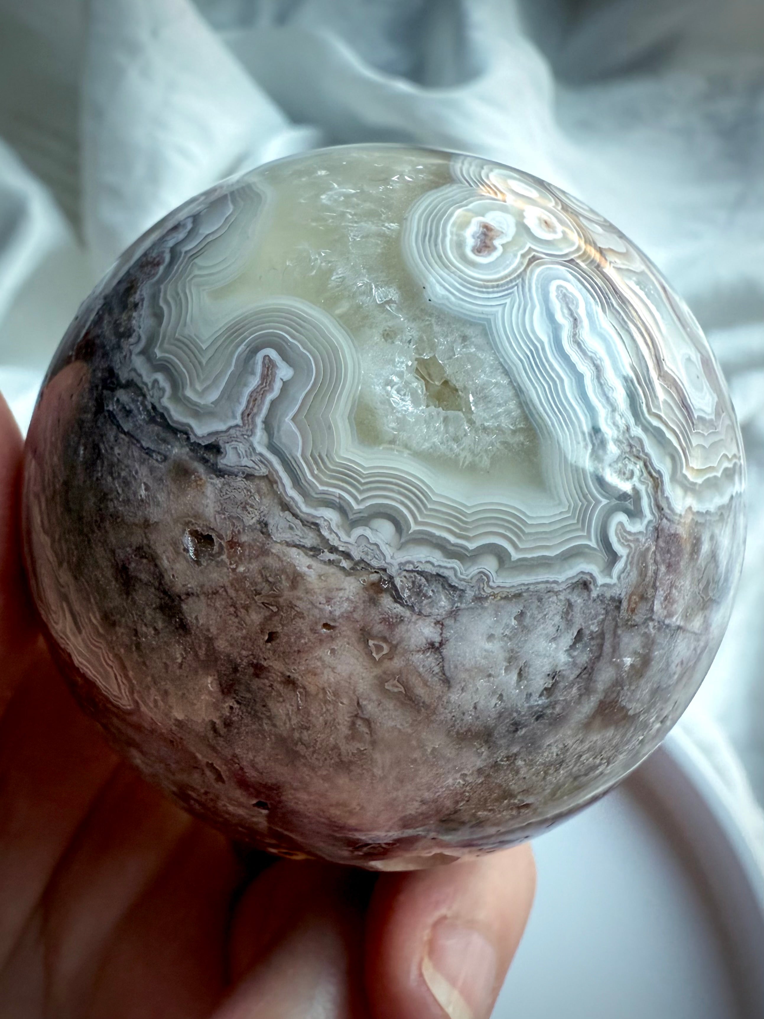 Detailed view of crazy lace agate sphere with earthy matrix and pale agate bands, perfect for grounding energy