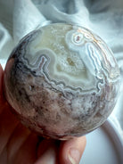 Detailed view of crazy lace agate sphere with earthy matrix and pale agate bands, perfect for grounding energy