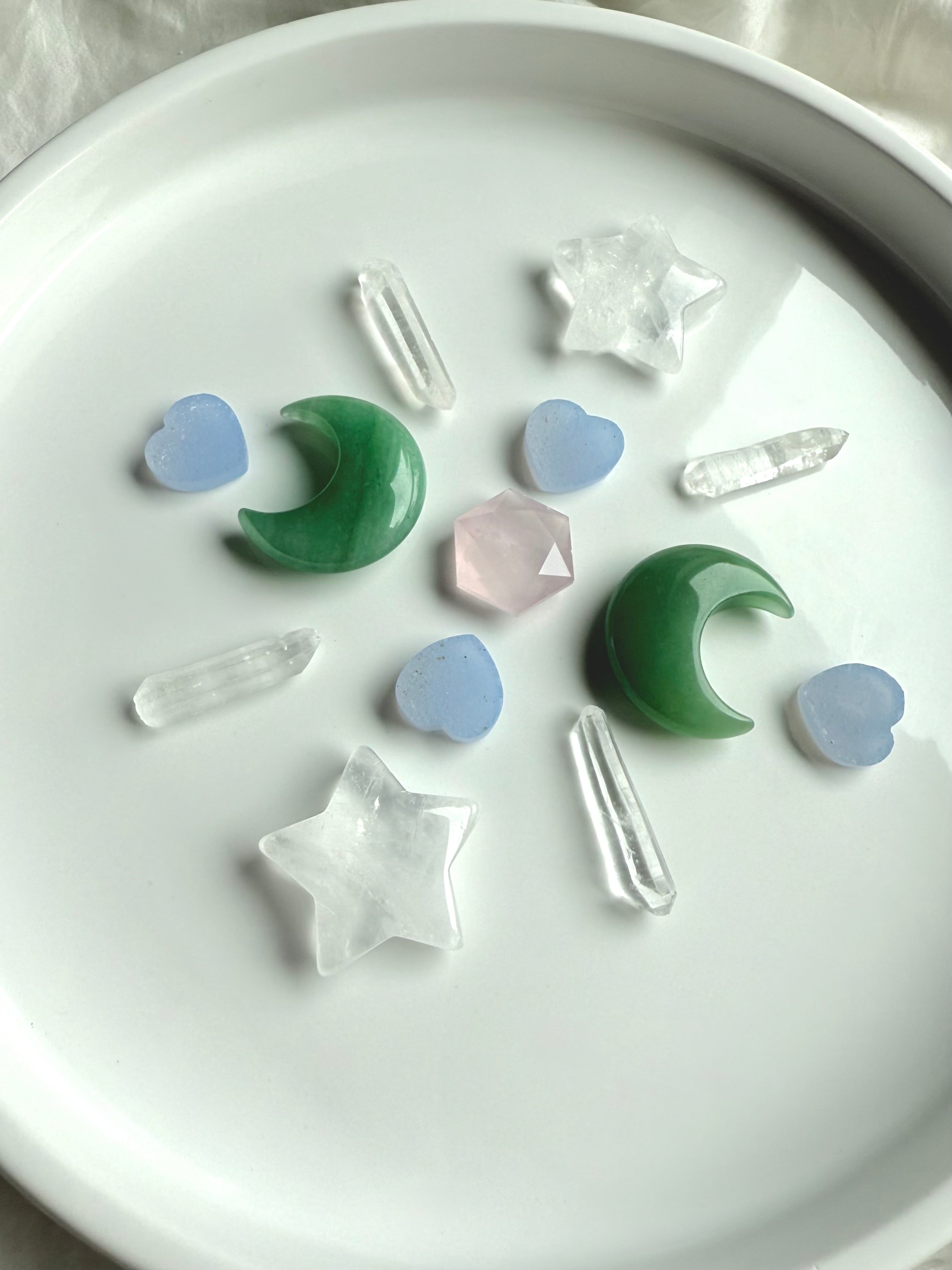 Crystal grid with Clear Quartz stars, Green Aventurine moons, Blue Chalcedony hearts, quartz points, and Rose Quartz hexagon in center, sacred geometry layout for heart chakra healing