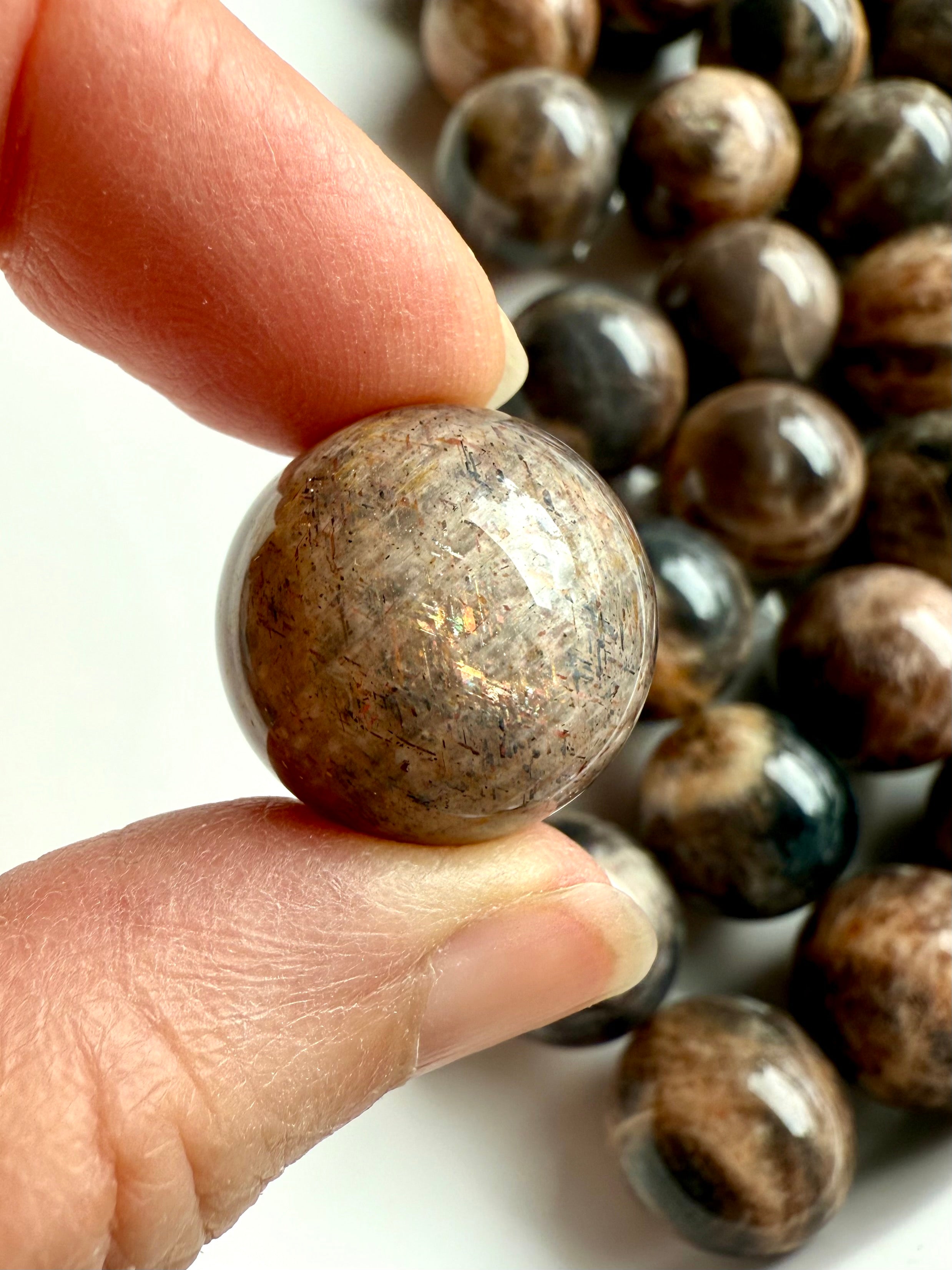 Closeup of Mini Black Moonstone sphere showing sunstone inclusions and shimmer
