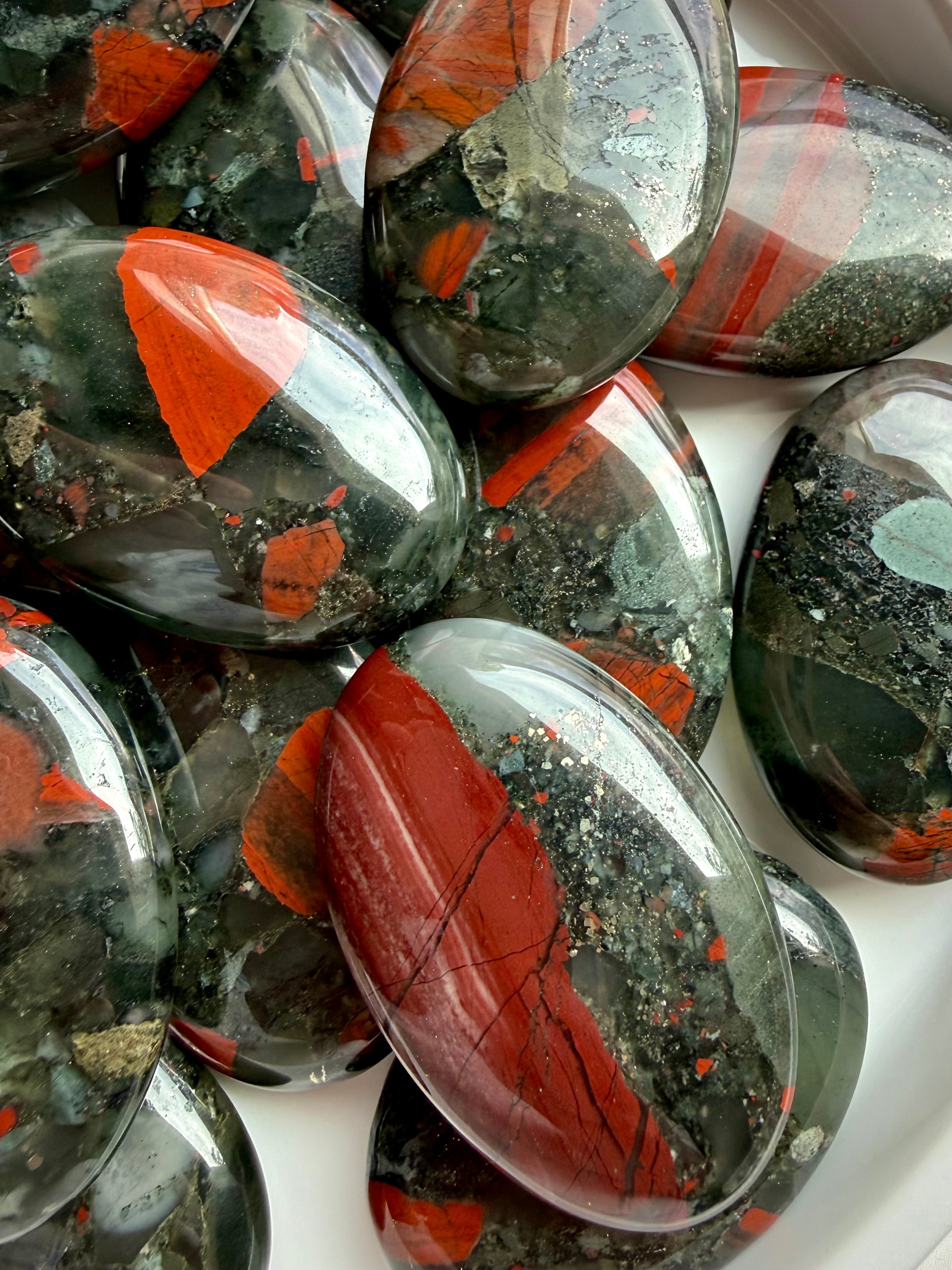 Bloodstone palm stones with striking red and green patterns, natural banding and varied mineral inclusions