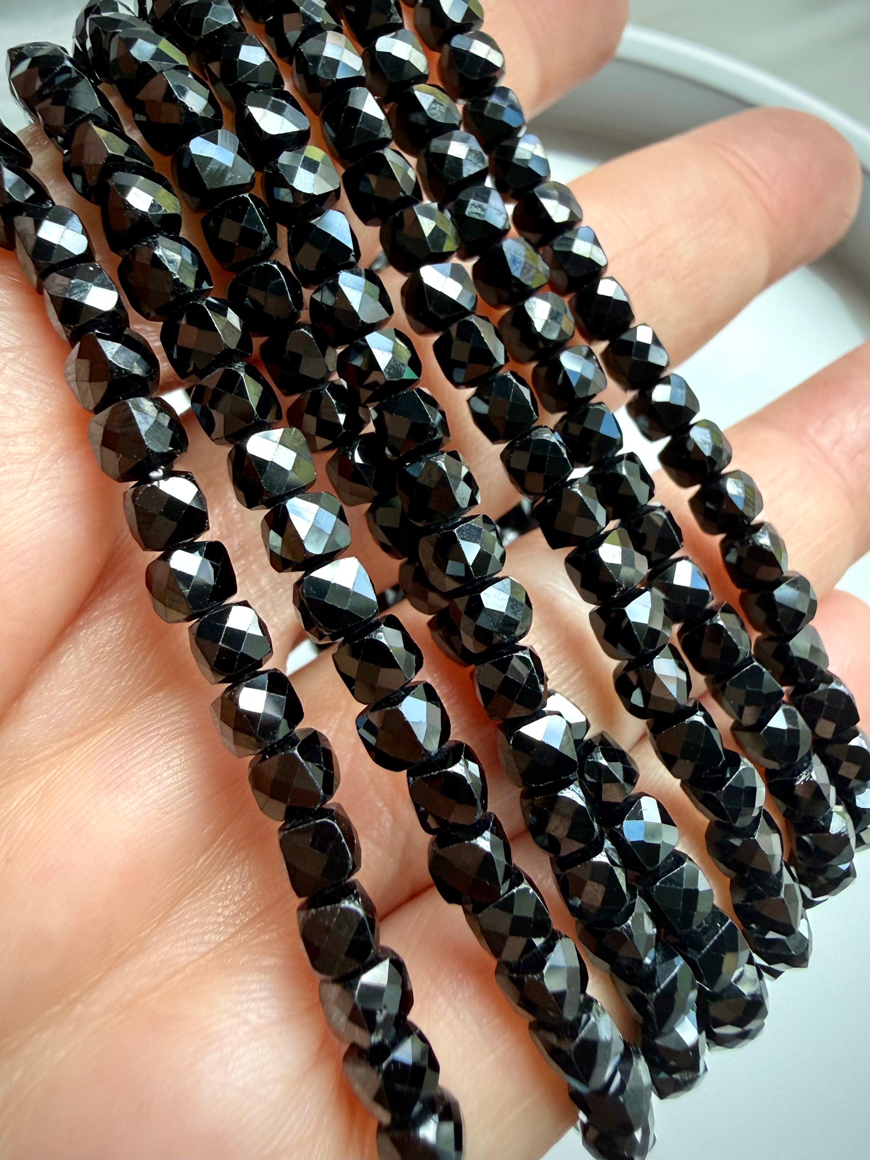 faceted black spinel bracelet strands in hand for protection grounding crystal jewelry