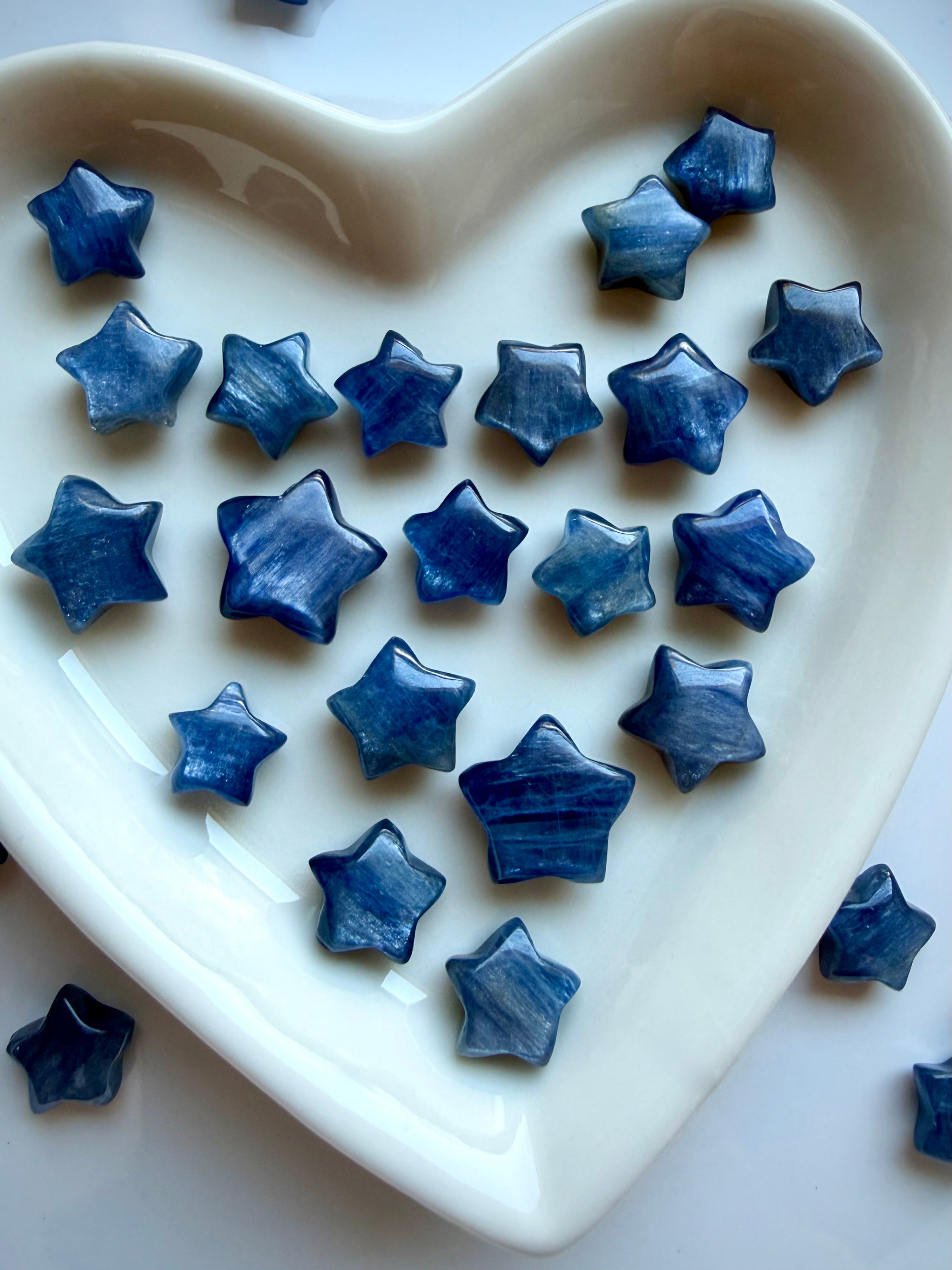 Polished Blue Kyanite crystal stars in a white heart dish with natural blue shimmer and unique patterning
