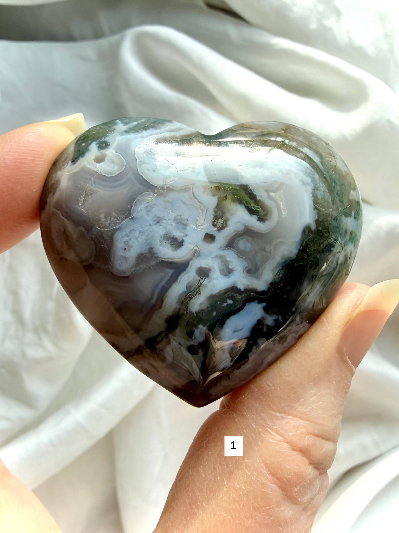 moss agate heart carving option 1 in hand with green moss inclusions and natural chalcedony pattern