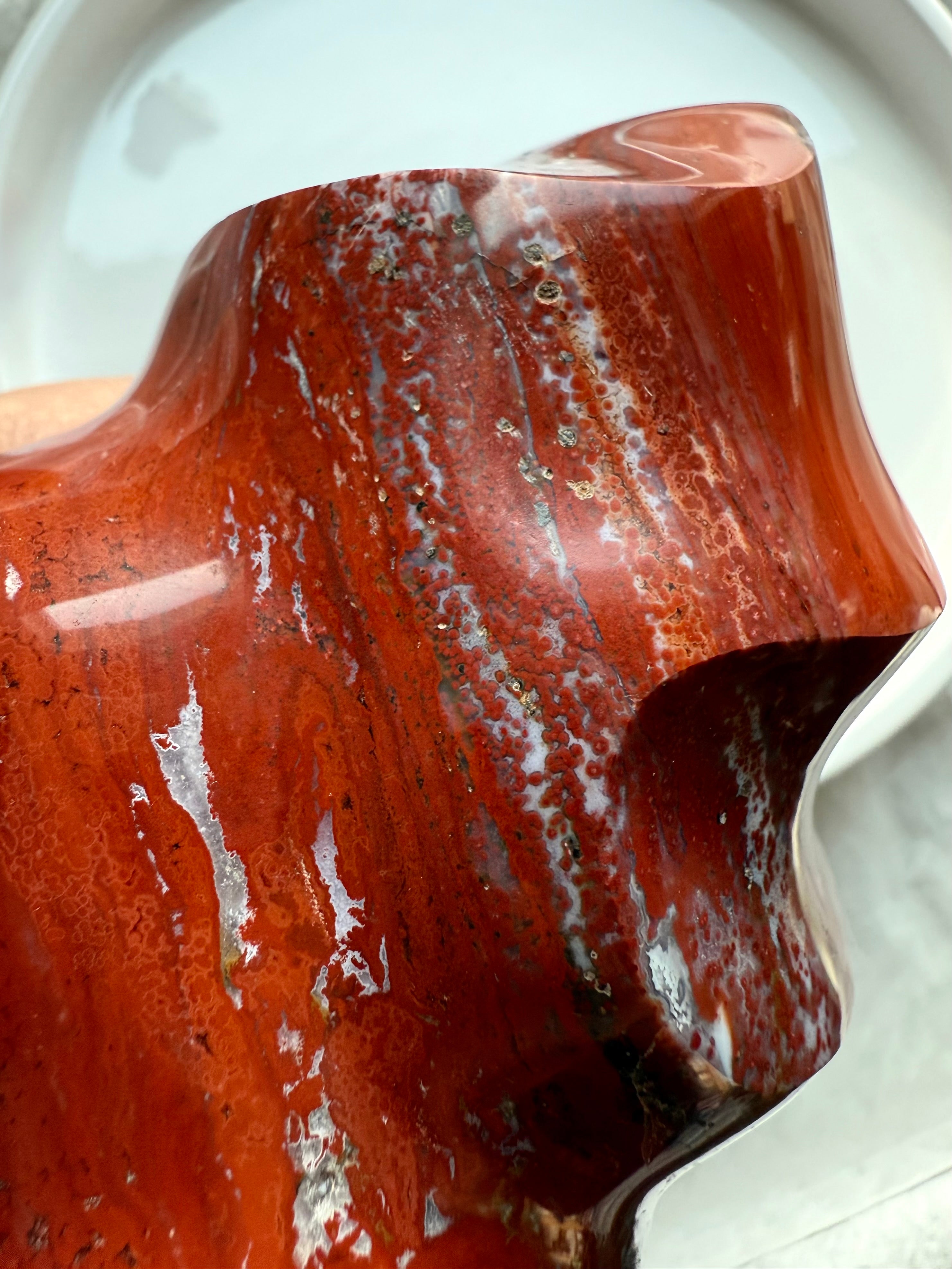 Close-up of Red Ocean Jasper flame highlighting intricate banding, orbicular patterns, and glossy polished surface.