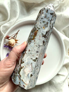 Polished Cosmic Ocean Jasper tower displaying mossy green inclusions, creamy chalcedony swirls, and raw druzy accents