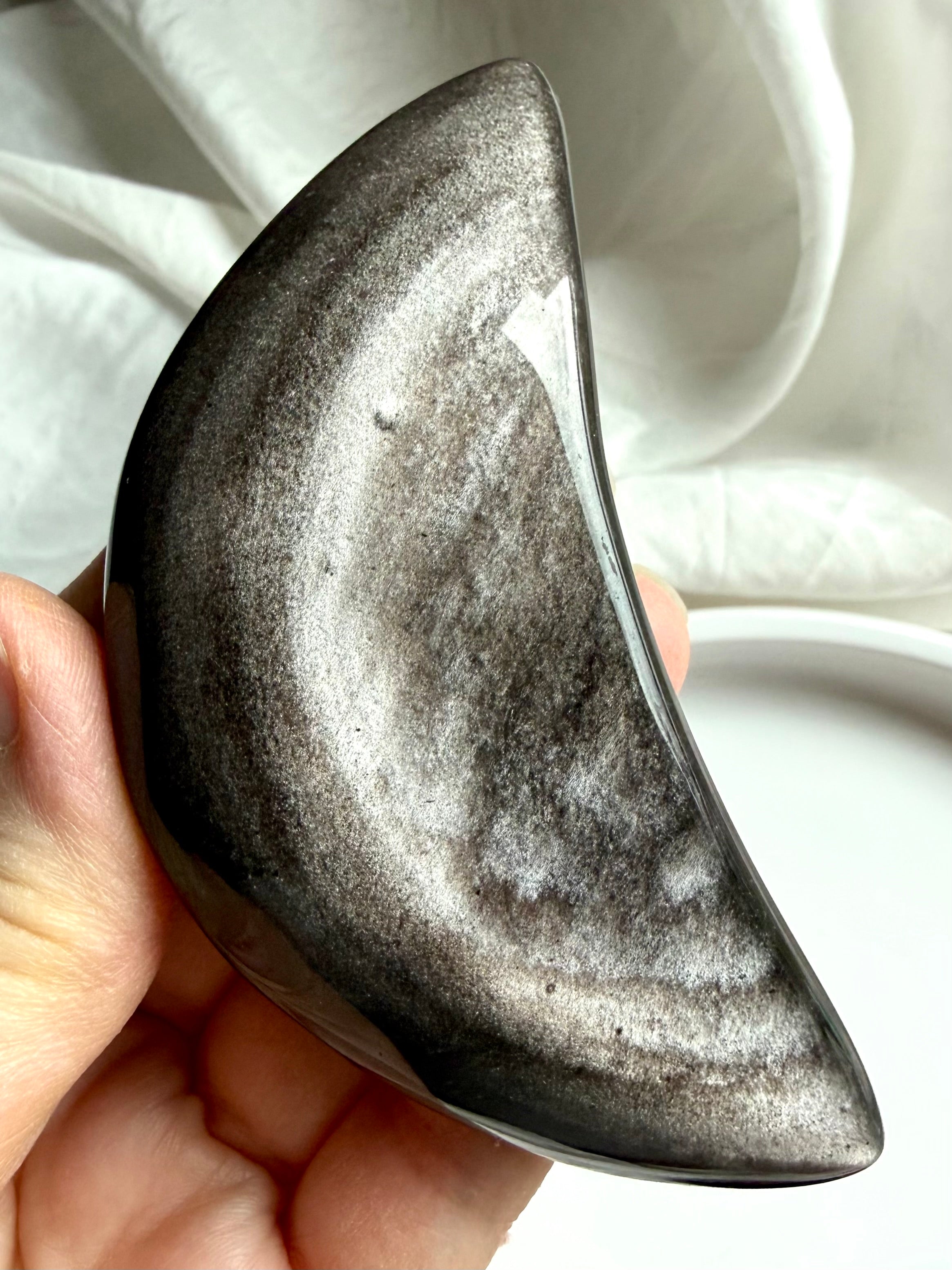 Silver Sheen Obsidian crescent moon crystal held in hand, polished obsidian for protection, insight, and grounding energy