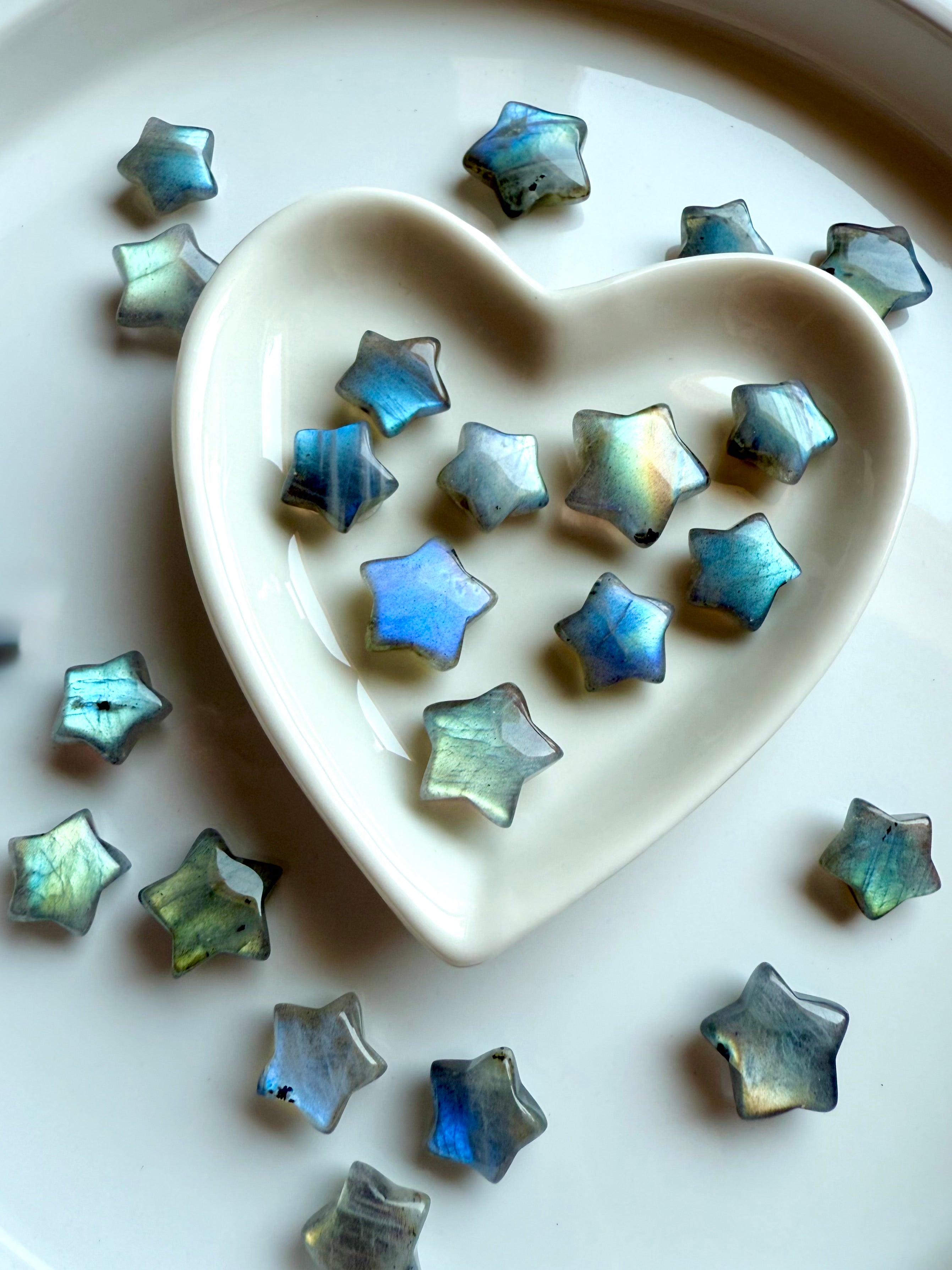 Overhead view of pastel Labradorite stars in a ceramic heart bowl — high-vibe micro crystal stars for intuition, calm & sacred space styling.