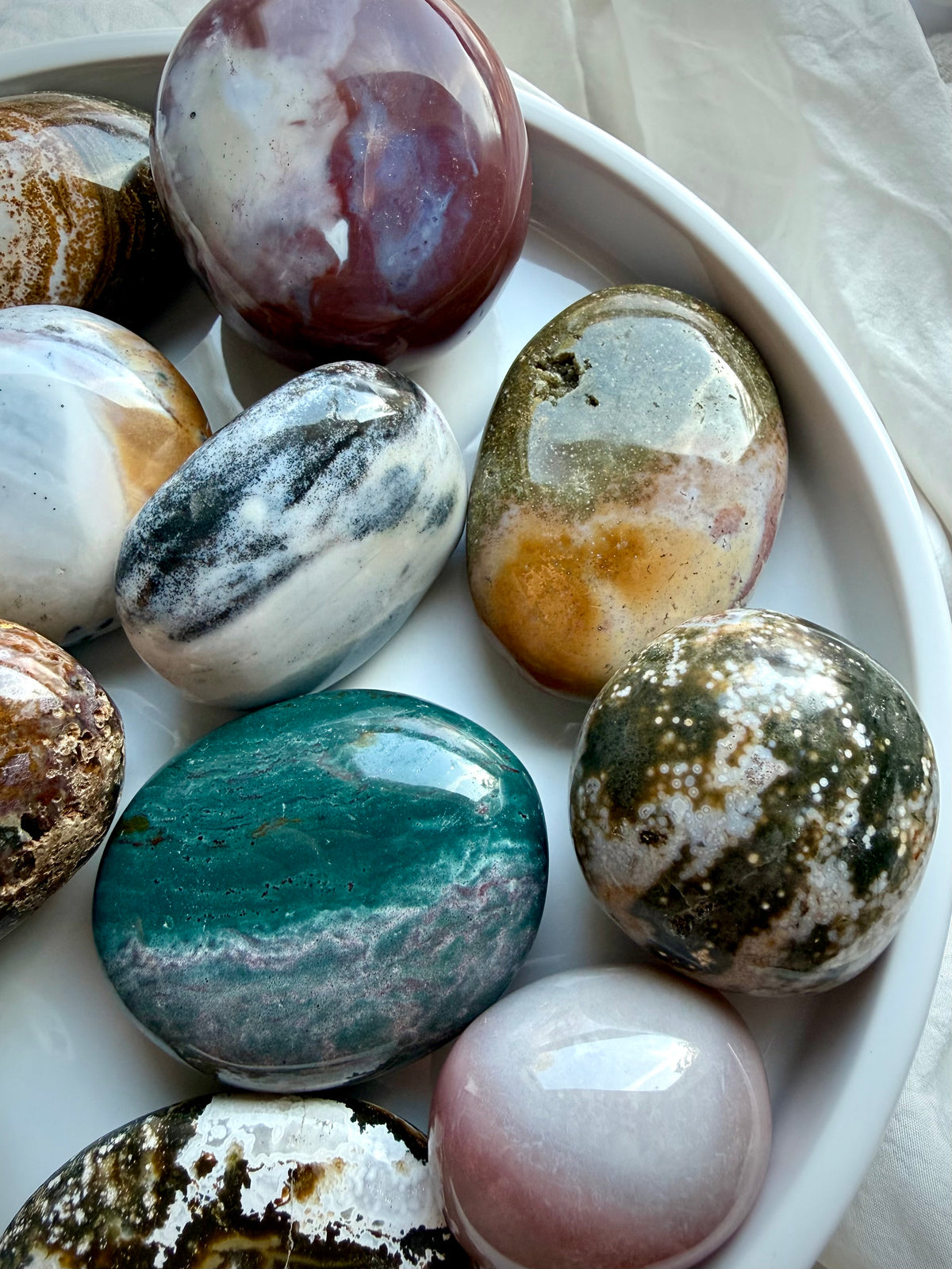 Ocean Jasper palm stone with earthy brown, cream, and white agate patterns, natural mineral inclusions, and glossy polish