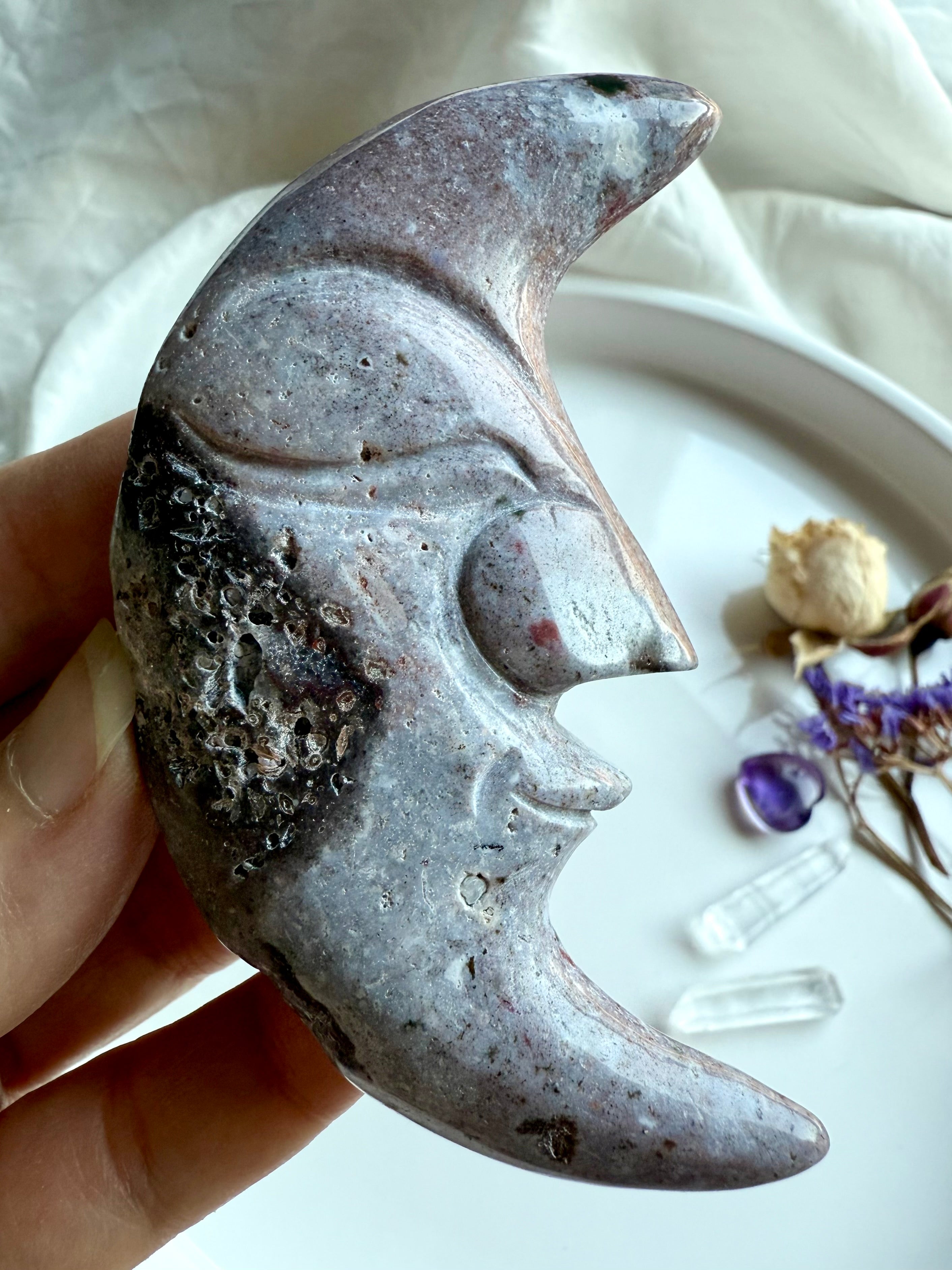 Ocean Jasper moon face carving in purple tones – polished gemstone carving with swirling patterns.