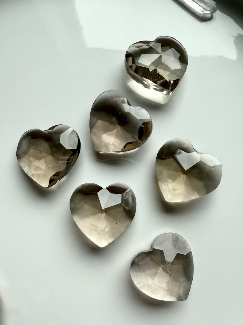 Close up of our Gem Cut Smokey Quartz Hearts shown on a white plate, photographed in natural light