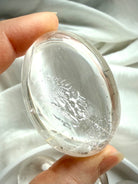 clear quartz palm stone close up with silvery flash and internal veiling