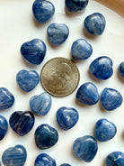 Mini Blue Kyanite heart crystals shown beside a US quarter for size reference, polished silvery blue throat chakra stones for meditation and crystal grids