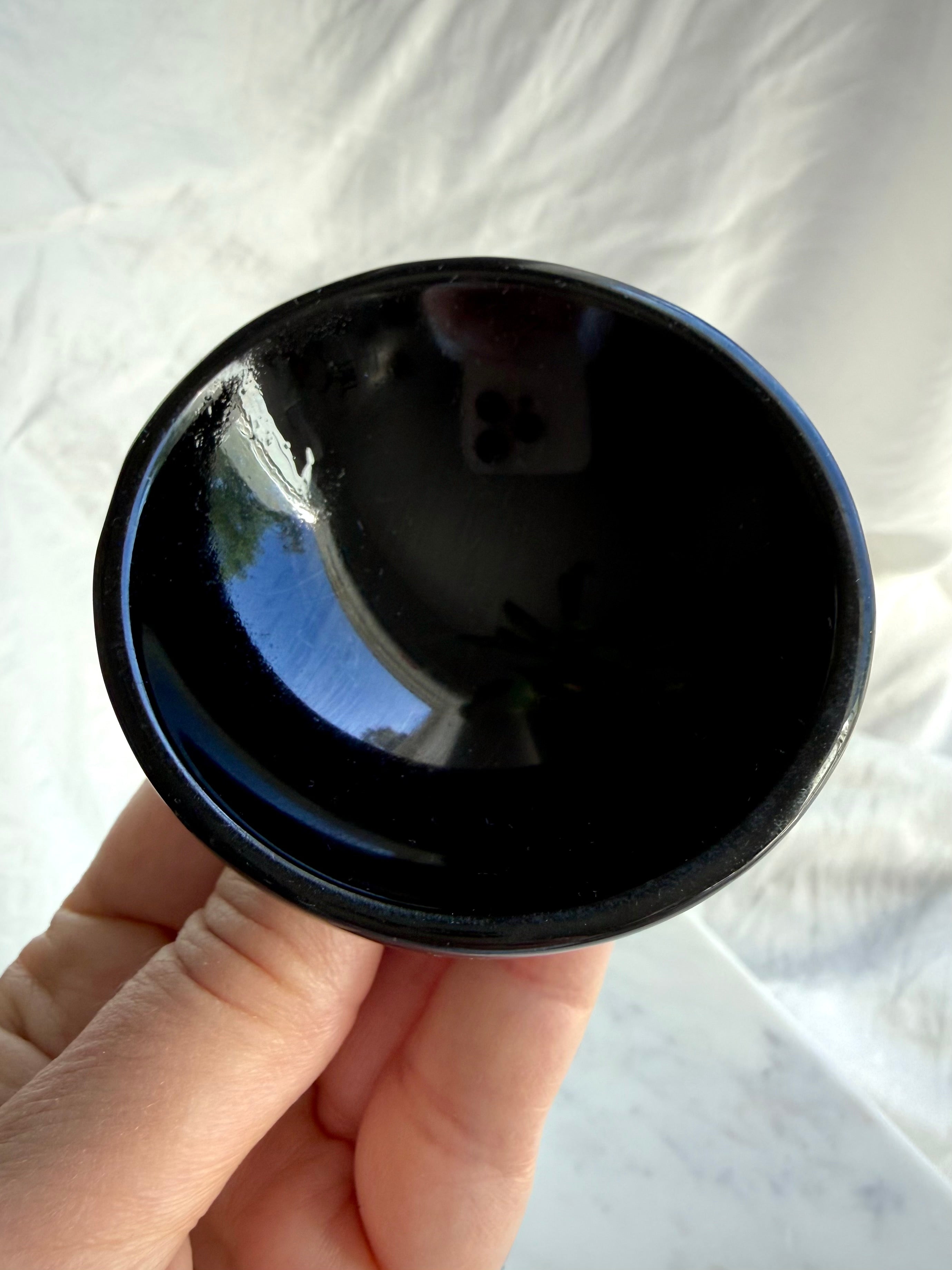 Round Black Obsidian bowl held in hand showing glossy volcanic glass finish