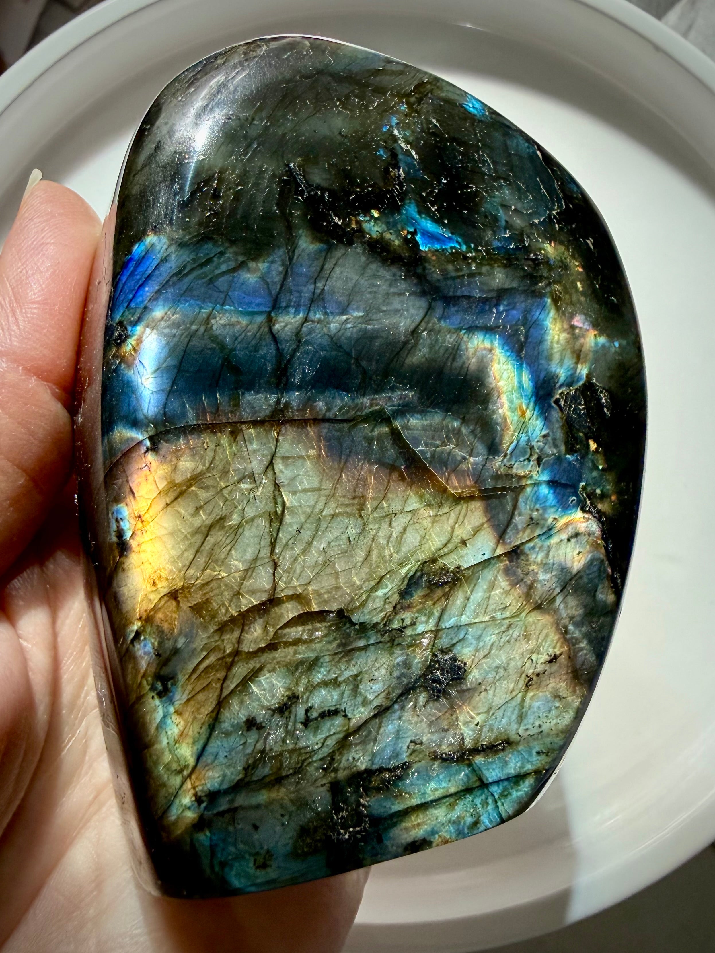 Reverse side of pink and purple Labradorite freeform showing blue, teal and golden labradorescence with natural dark matrix