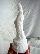White Jade Standing Quan Yin statue held in hand from the side, showing flowing robes and natural crystalline sparkle