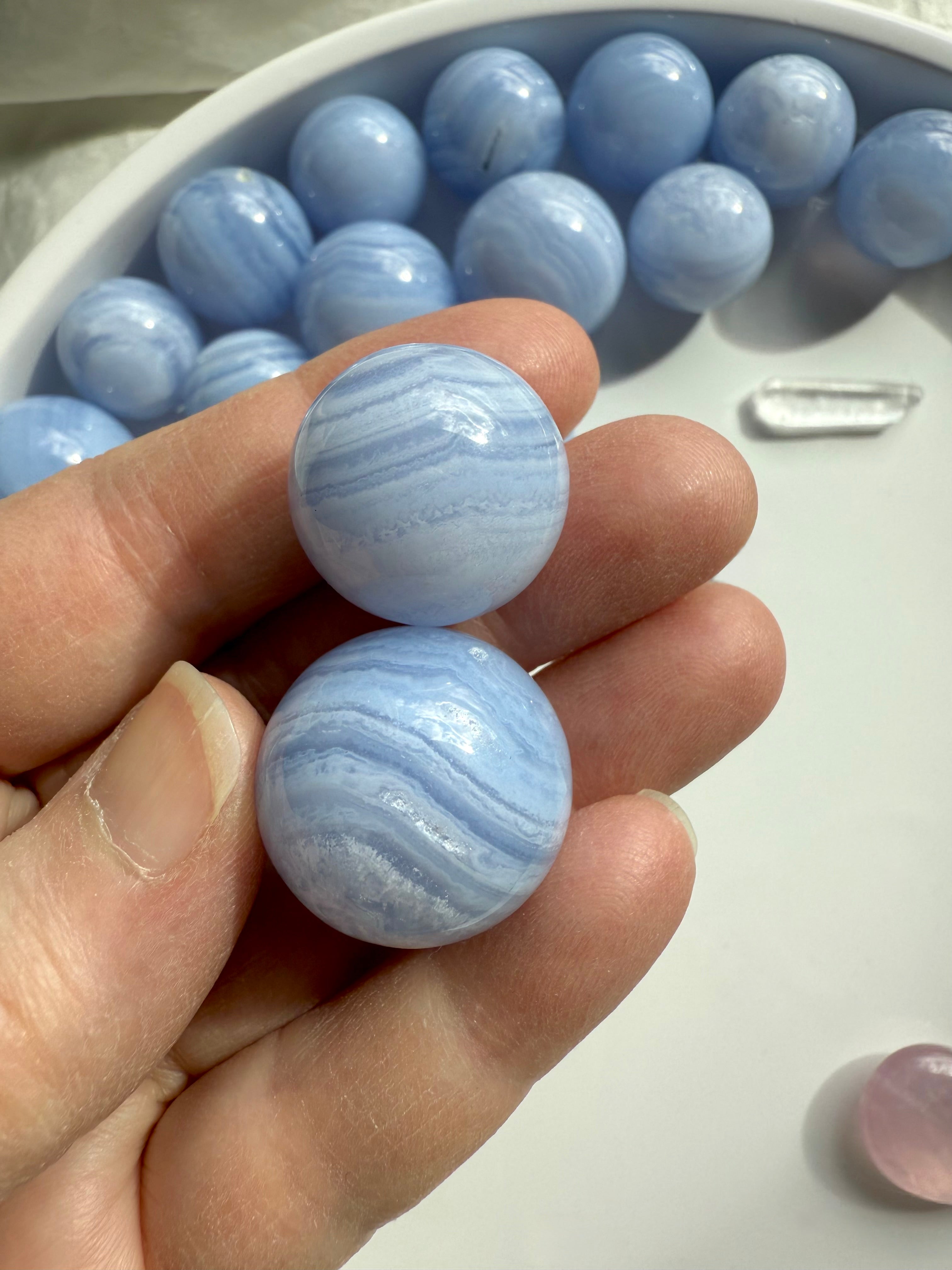 High quality mini Blue Lace Agate Spheres shown on my hand for scale