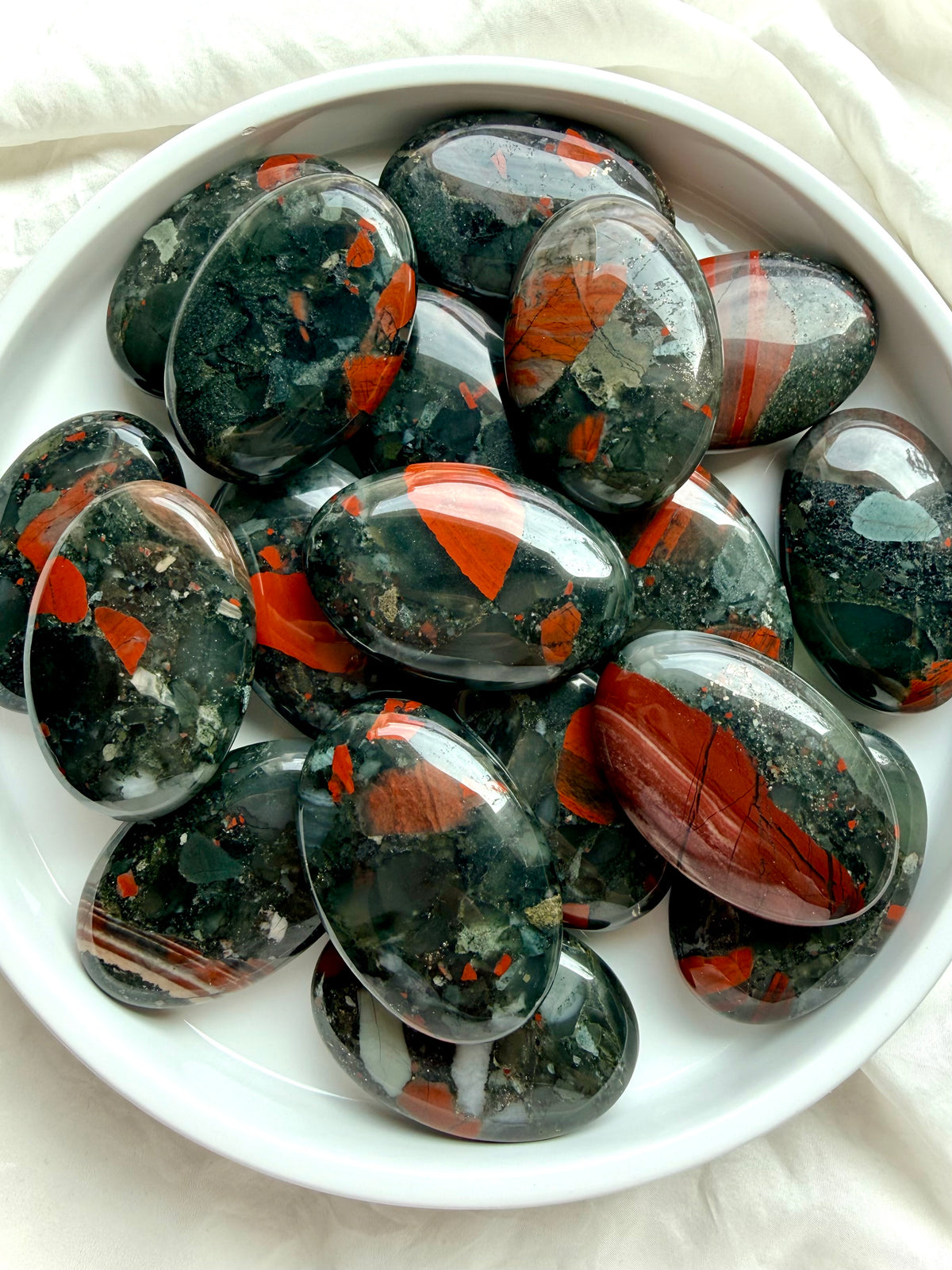Bloodstone palm stones with deep green, vivid red and earthy mineral patterns for strength, courage and vitality