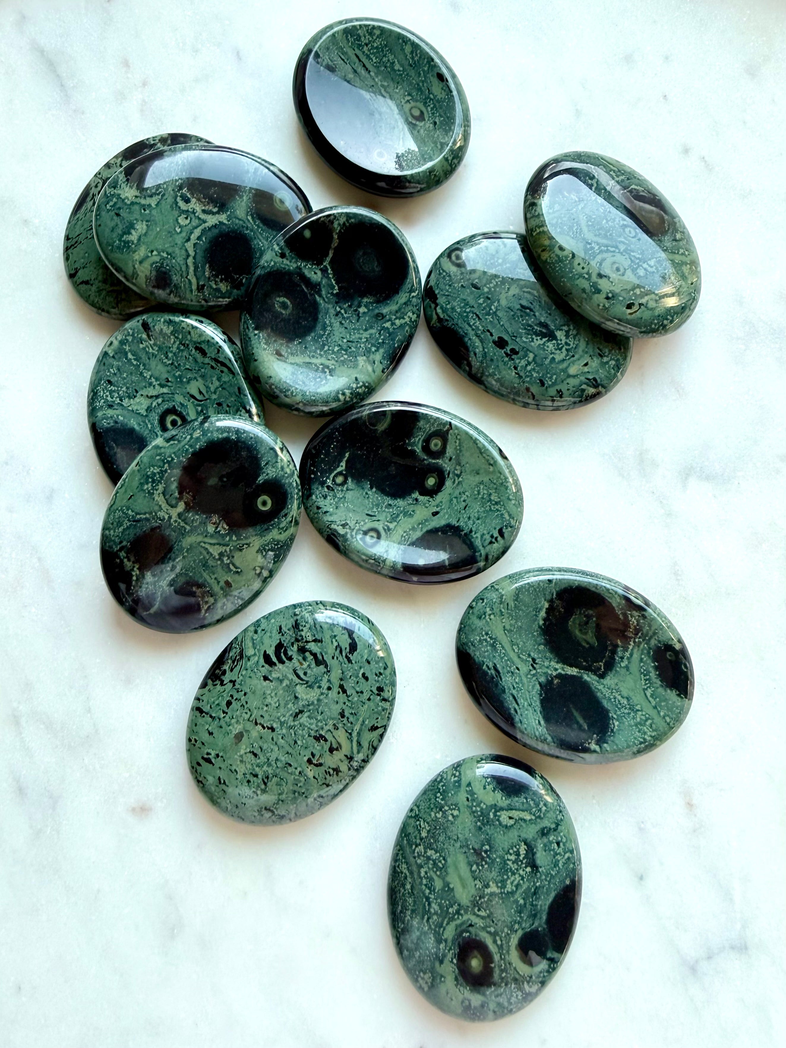 Polished Kambaba Jasper worry stones with green, dusky teal, and black eye-like patterns, Heart and Root Chakra crystal