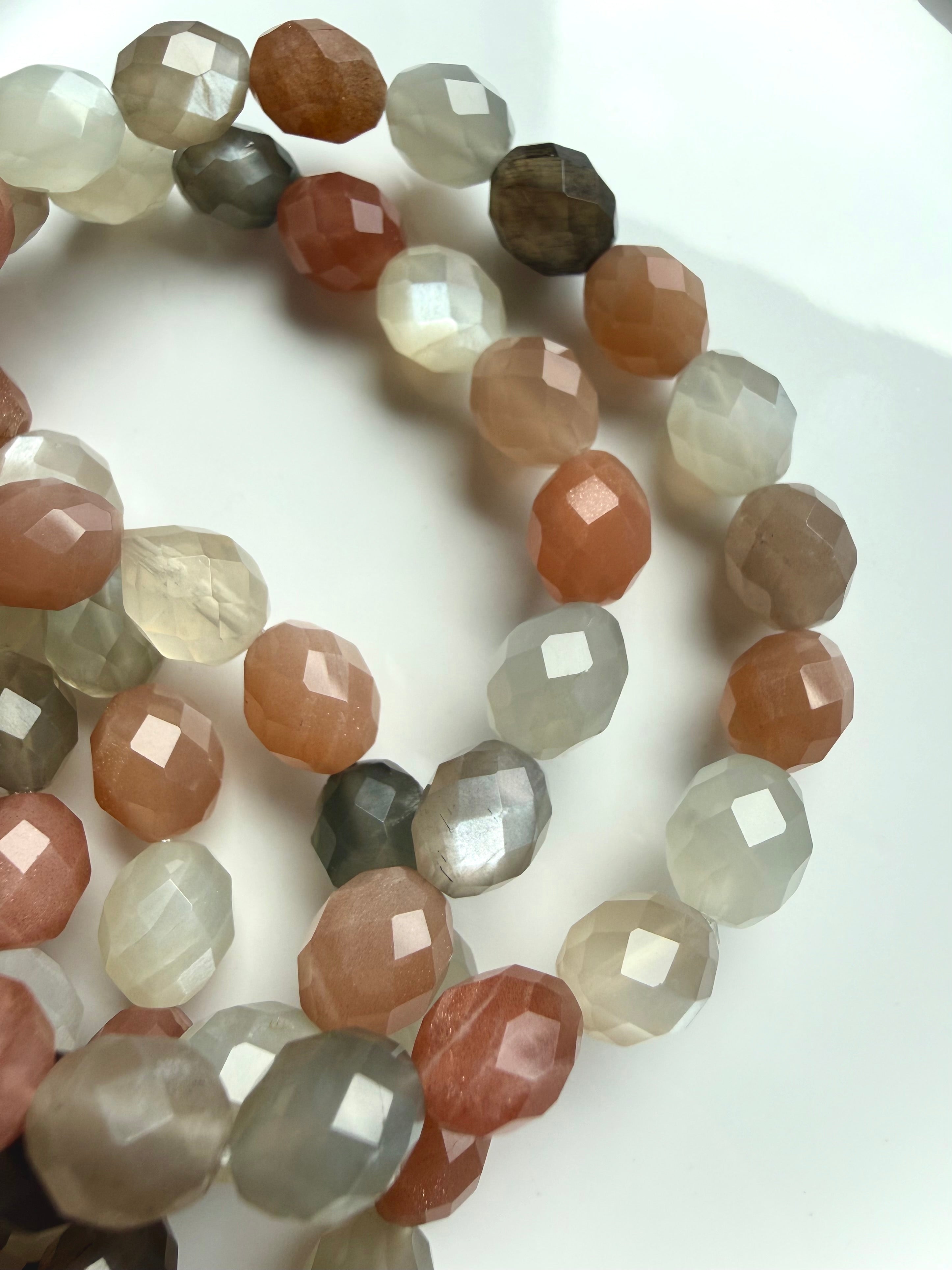 Close-up of natural Faceted Moonstone bracelets showing peach and gray gemstones, silky shimmer, and occasional needle-like inclusions