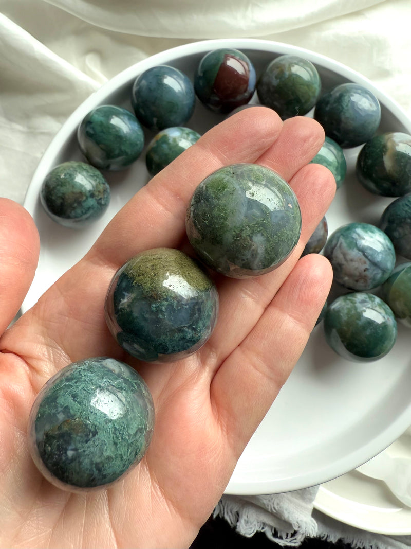 Colorful moss agate mini spheres shown on my hand