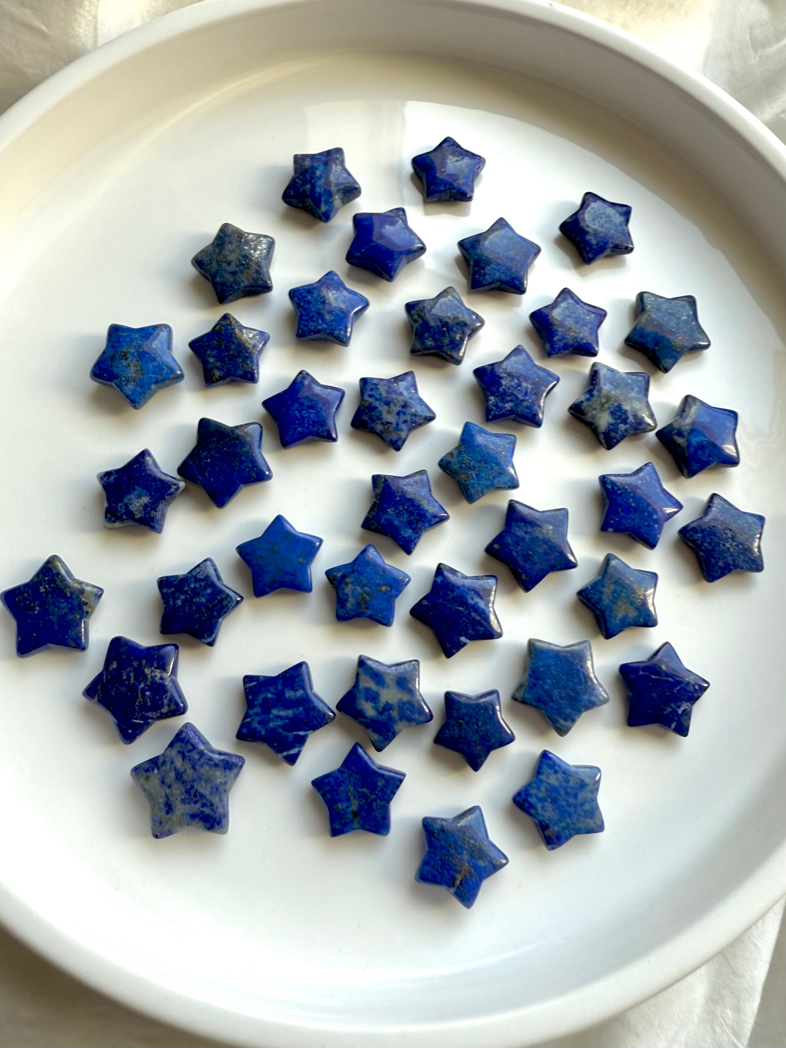 Multiple Mini Lapis Lazuli star crystals on white background 