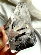 Black Tourmaline in Quartz freeform crystal with dramatic black tourmaline needles, held in hand for scale
