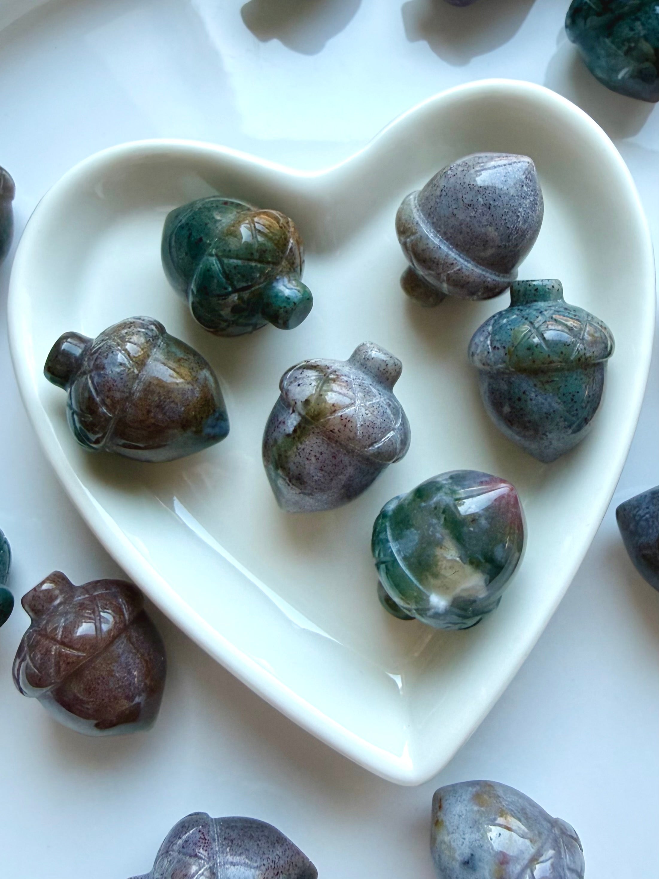 Polished Ocean Jasper acorns displayed in a white heart dish with teal, lavender, cream and earthy color variations