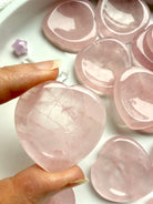 Rose quartz heart worry stone held in hand – polished heart-shaped crystal thumb stone for love and emotional healing