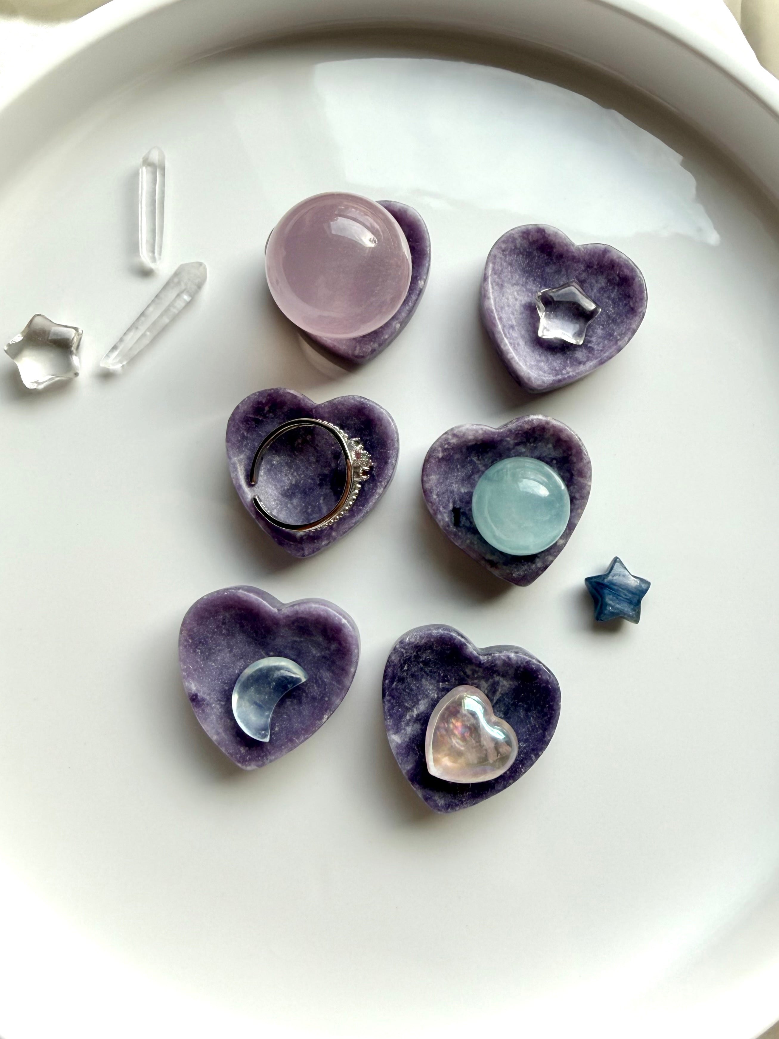 Mini Lepidolite heart bowls holding mini spheres, jewelry and tiny crystals as petite crystal displays