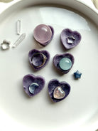 Mini Lepidolite heart bowls holding mini spheres, jewelry and tiny crystals as petite crystal displays