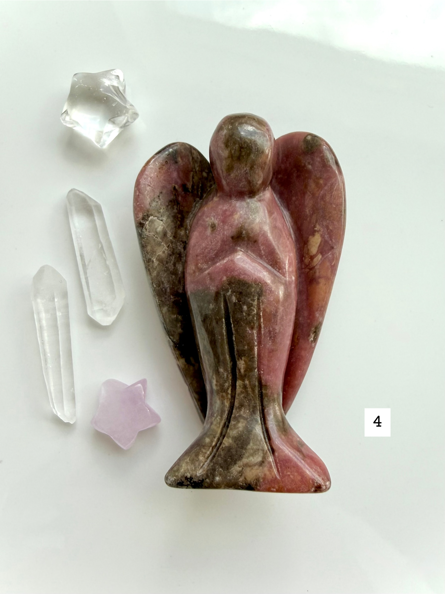 Rhodonite angel carving with bold black inclusions and pink matrix for love and protection
