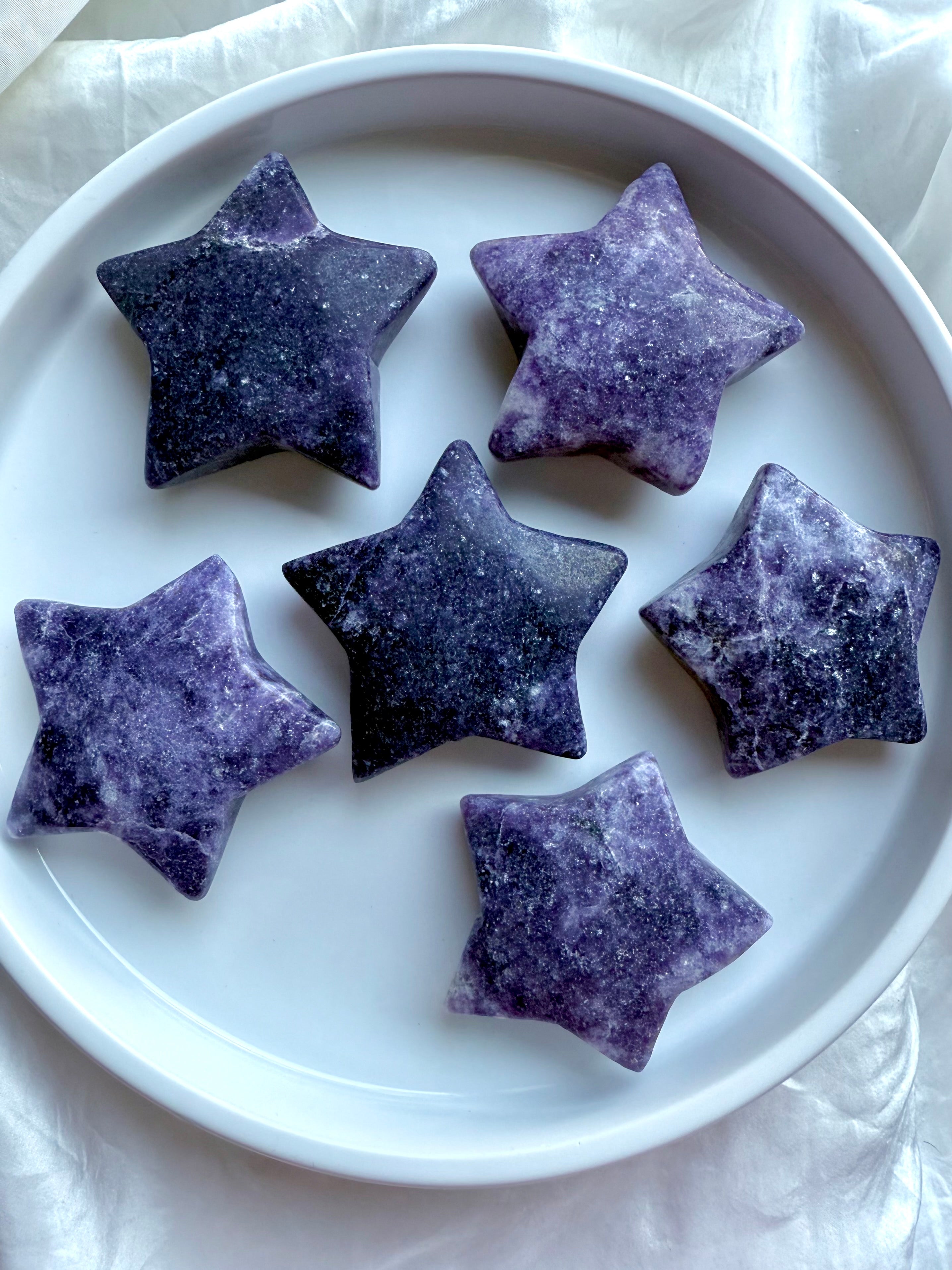 Back view of large Lepidolite star carvings in rich purple and lavender tones, natural stone texture visible.