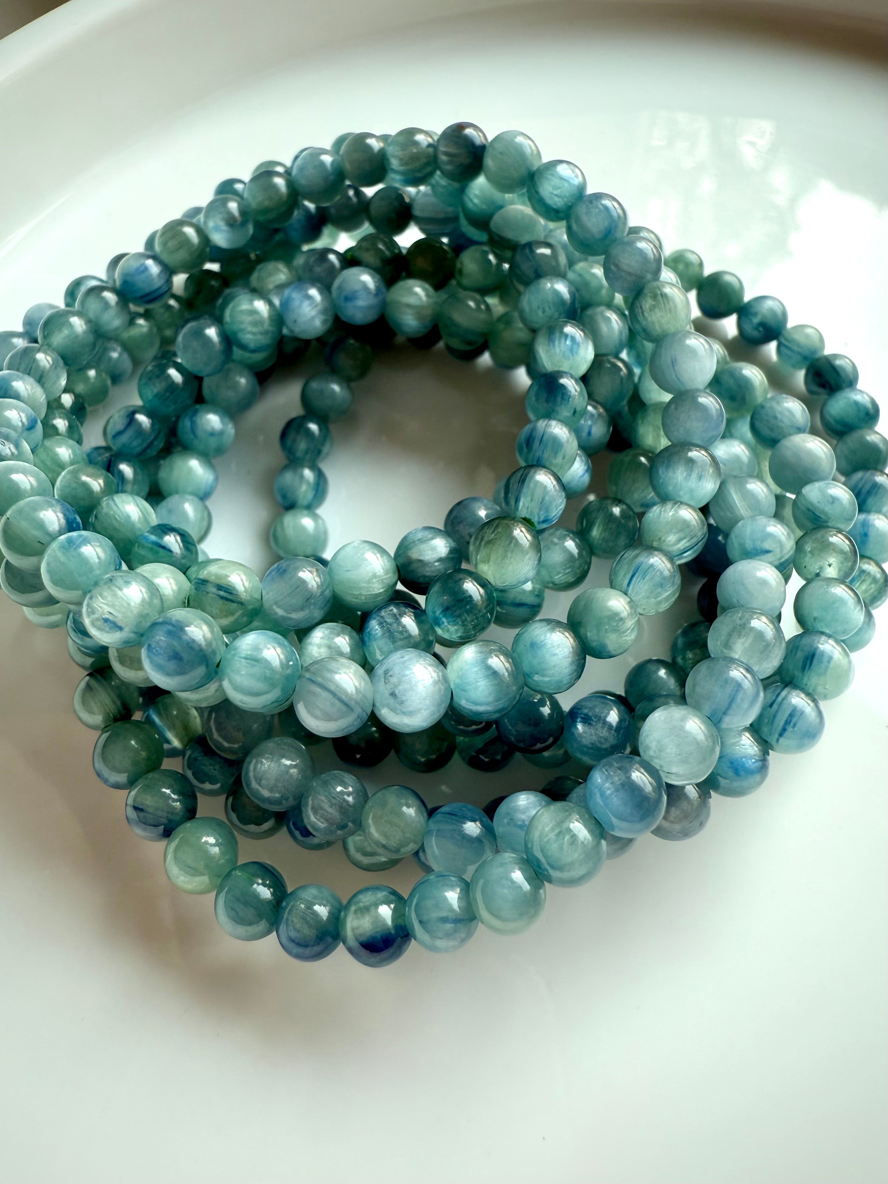 stacked blue-green kyanite bracelets reflecting soft light and color gradients, ideal for gifting or ritual use