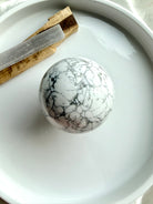 Howlite sphere with palo santo and selenite on white tray, calming crystal ball for meditation, sleep support and peaceful energy