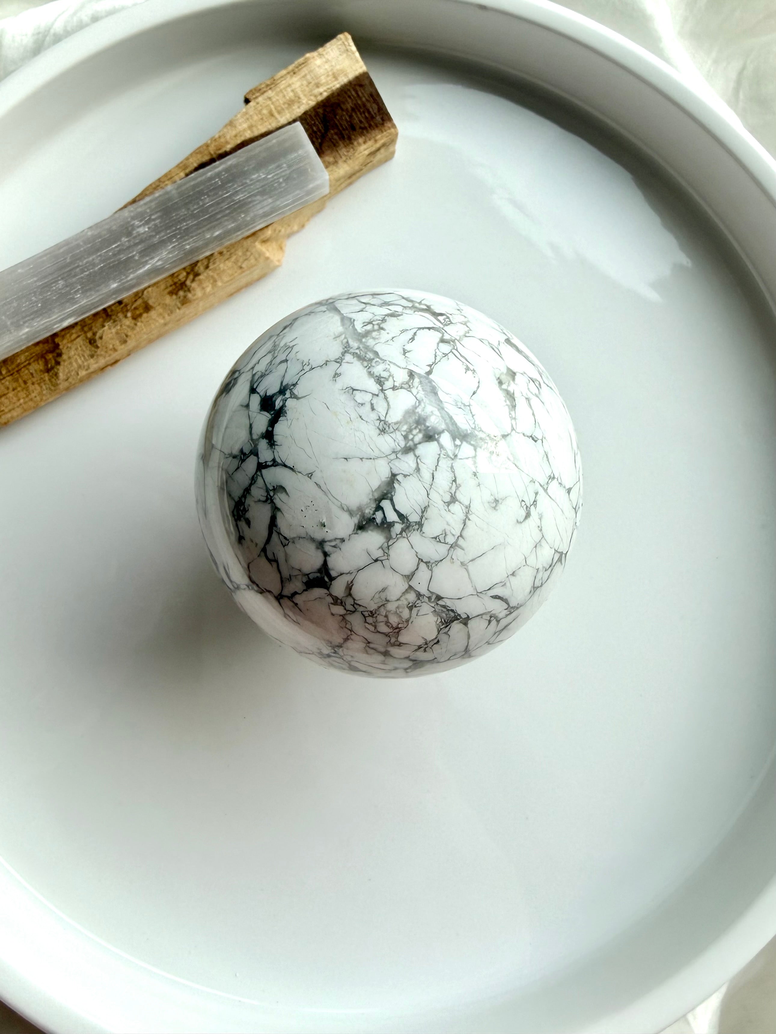 Howlite sphere with palo santo and selenite on white tray, calming crystal ball for meditation, sleep support and peaceful energy