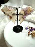 Amethyst druzy and agate butterfly wings displayed on metal stand, shimmering lavender crystals and earthy agate banding for altar décor and spiritual transformation.