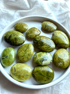 Overhead view of Green Opal palms on a white plate, angled to show natural variations in size, color, and texture.