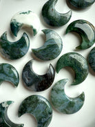 Styled flat lay of Moss Agate crescent moons for altar decor or crystal grid use.